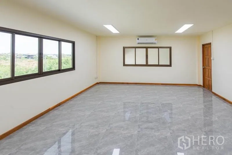 Factory for sale in Bang Sao Thong, Samut Prakan - Upper office room with wide windows, air conditioner and gray tile flooring.