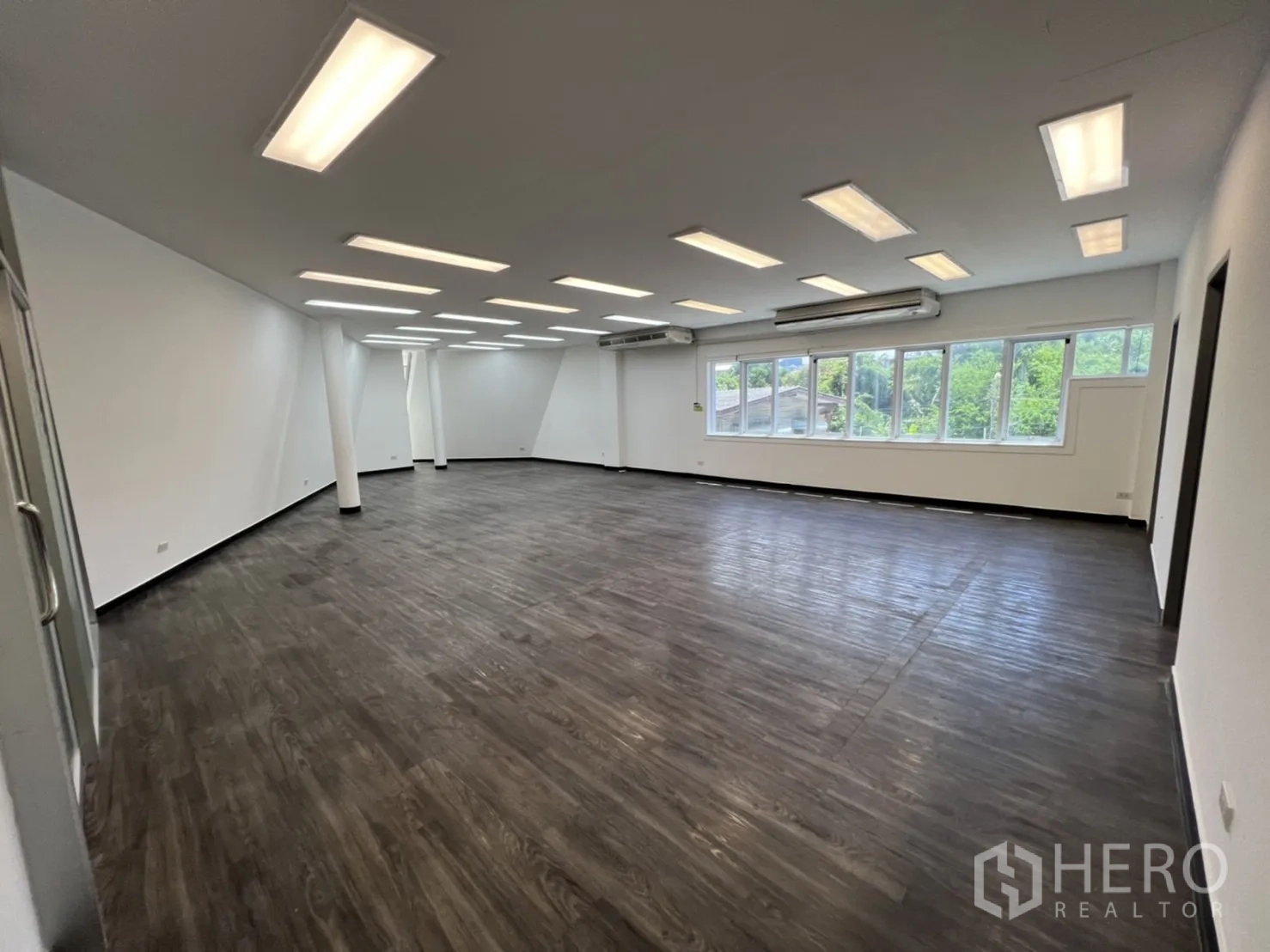 พื้นที่ขายปลีก ให้เช่าในSathon, Bangkok - ฮอลล์ออฟฟิศแบบเปิด ไฟเพดานเรียงตัว และวิวสีเขียวผ่านหน้าต่าง