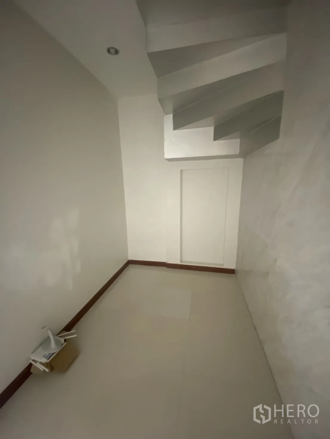 Shophouse for rent in Bang Rak, Bangkok - Small hall beneath the stairs with tiled floor and recessed lighting.