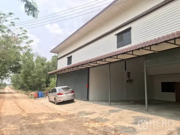 货栈 出租在Pathum Thani - 外立面带多樘卷帘门及混凝土前场，可停车与装卸。