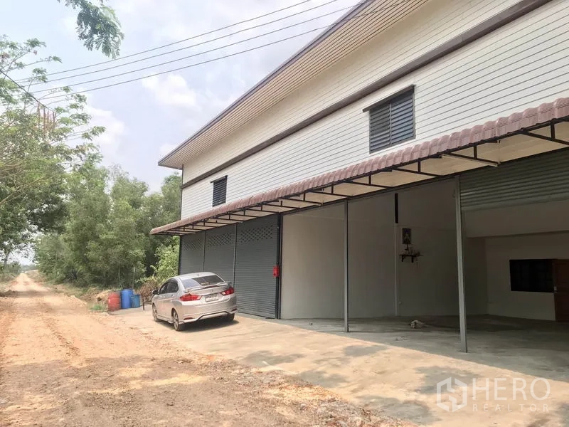 货栈 出租在Pathum Thani - 外立面带多樘卷帘门及混凝土前场，可停车与装卸。