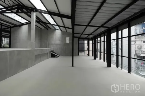 零售空间 出租在Watthana, Bangkok - 开放式零售室内，落地窗、高挑钢结构屋顶、天窗与光滑混凝土地面。