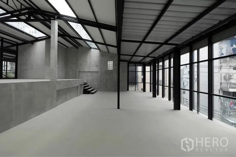 零售空间 出租在Watthana, Bangkok - 开放式零售室内，落地窗、高挑钢结构屋顶、天窗与光滑混凝土地面。