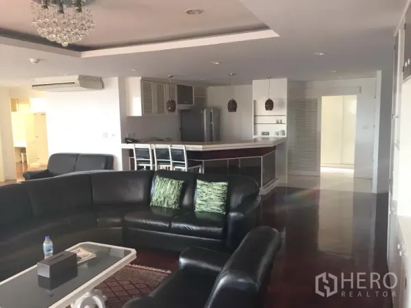 Condominium for rent in Watthana, Bangkok - Modern open kitchen with breakfast bar, pendant lights, and stools adjoining the lounge.