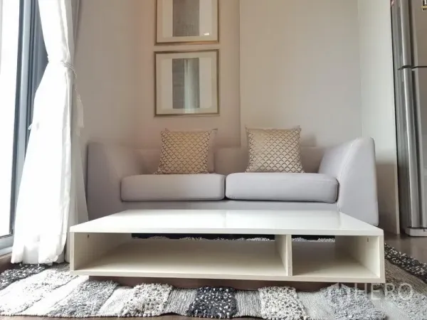 公寓 出租在Ratchathewi, Bangkok - 灰色沙发与靠垫，低矮白色茶几，墙面装饰画点缀。
