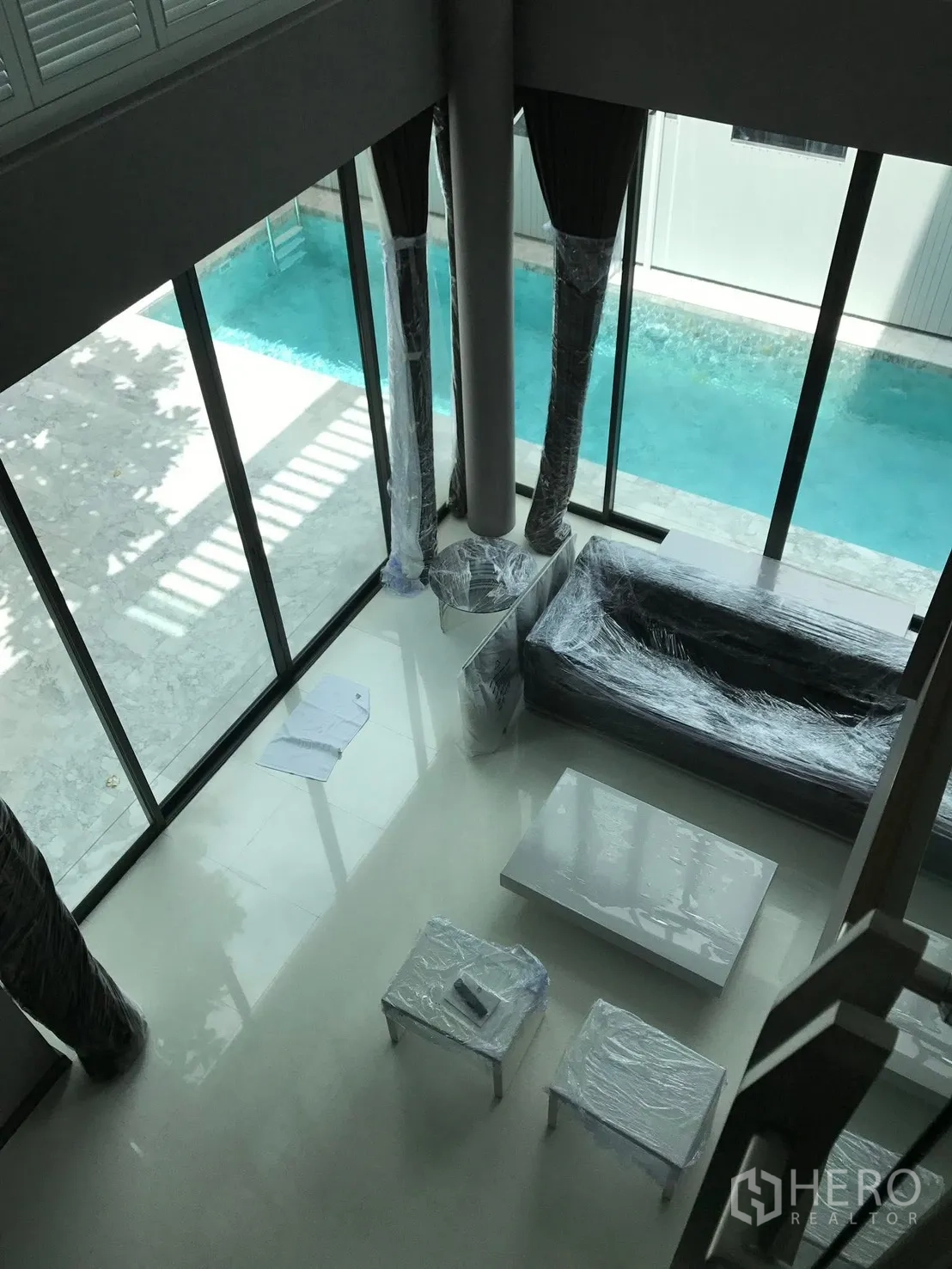 บ้านเดี่ยว for rent in Bang Kapi, Bangkok - ห้องนั่งเล่นเพดานสูง ผนังกระจกสูงเต็มบาน เปิดสู่สระว่ายน้ำส่วนตัวแบบยาว