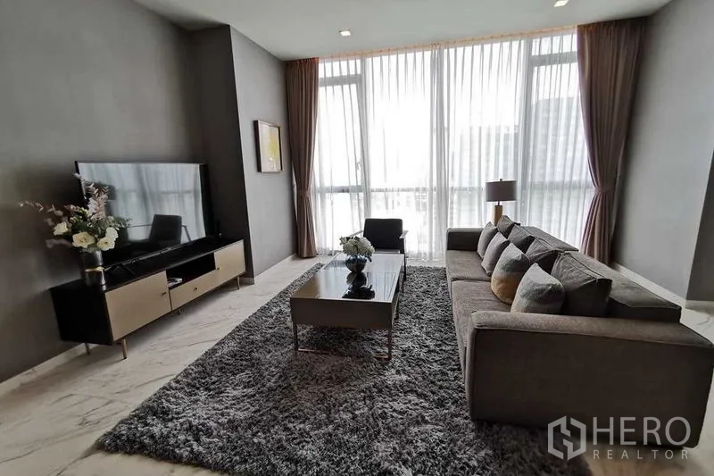 公寓 出租或出售在Watthana, Bangkok - 温馨休闲区，电视柜、花饰与高挑窗帘。