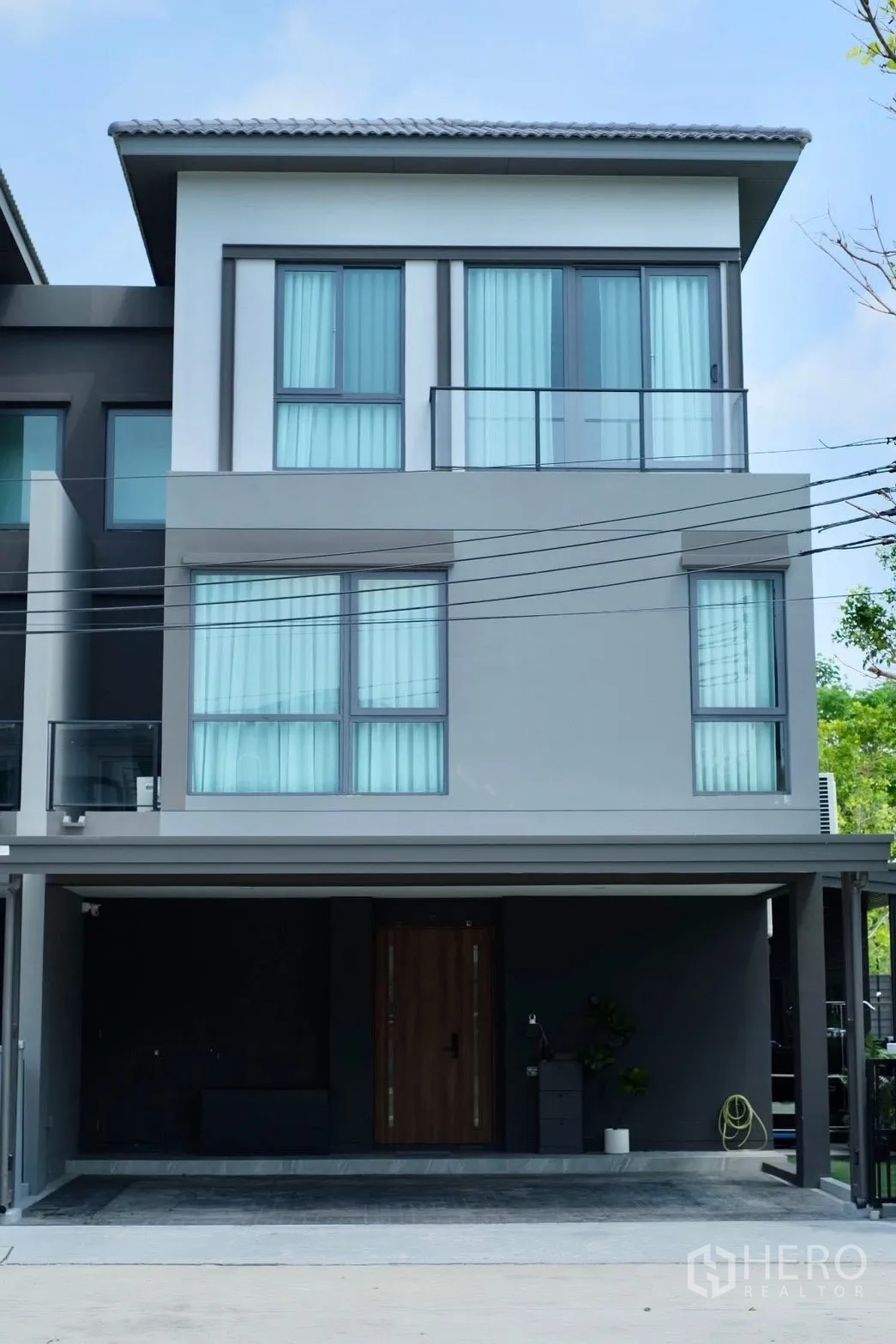 Semi-detached House for sale in Prawet, Bangkok - Front façade of a three-storey semi-detached house with wide carport.