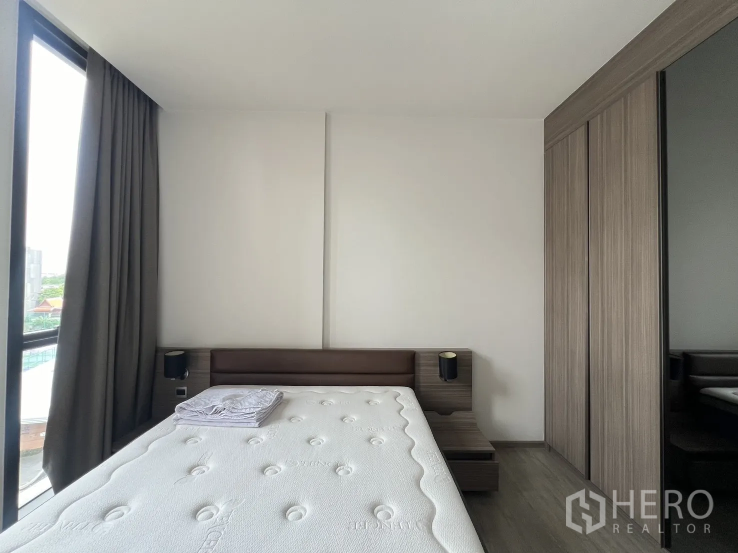คอนโด for rent in Watthana, Bangkok - ห้องนอนมีหน้าต่างบานใหญ่ ผ้าม่านทึบแสง และตู้เสื้อผ้าลายไม้