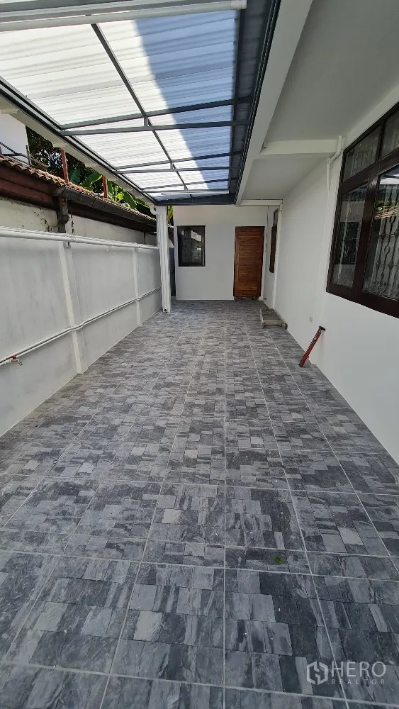 บ้านเดี่ยว for rent in Lat Phrao, Bangkok - เฉลียงหรือที่จอดรถข้างบ้านปูพื้นกระเบื้อง มีหลังคาโปร่งแสง