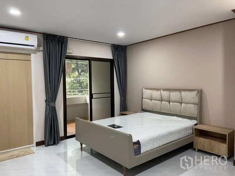 公寓 出租或出售在Watthana, Bangkok - 明亮卧室，软包床头与床头柜，灰色窗帘，推拉门通向观景阳台。