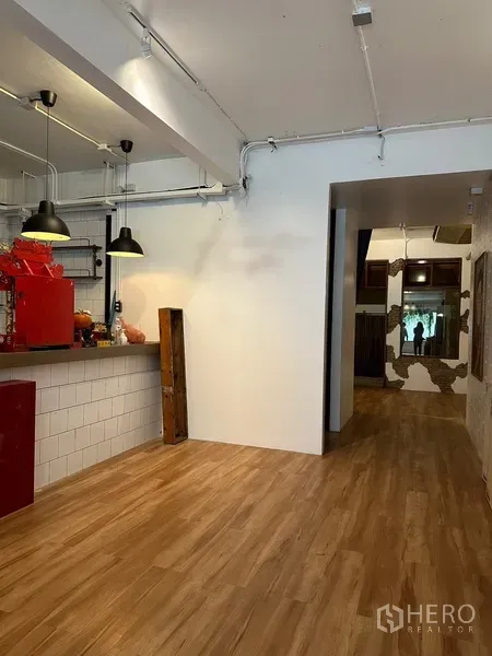 带办公室的家 出租在Watthana, Bangkok - 一层开放式空间，咖啡吧台、吊灯与木纹地板。