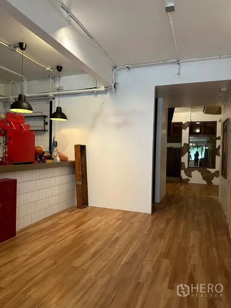 带办公室的家 出租在Watthana, Bangkok - 一层开放式空间，咖啡吧台、吊灯与木纹地板。