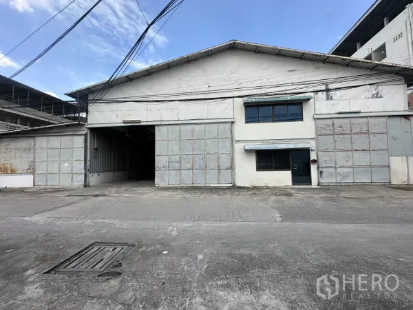 Warehouse for rent in Suan Luang, Bangkok - Front elevation of Suan Luang warehouse with wide folding steel gates and office windows.