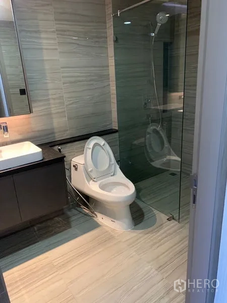 คอนโด ให้เช่าในPathum Wan, Bangkok - ห้องน้ำสมัยใหม่ มีตู้กระจกอาบน้ำ เคาน์เตอร์อ่างล้างหน้า และผนังกระเบื้อง