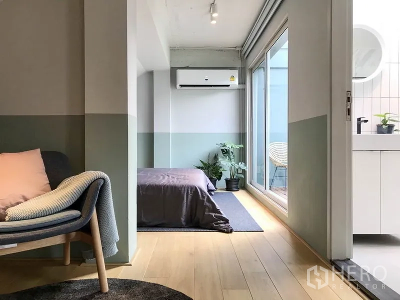 Townhouse for rent in Khlong Toei, Bangkok - Secondary bedroom with sliding doors to a terrace and an ensuite vanity area.