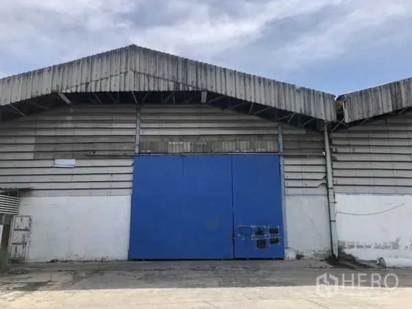 货栈 出租在Bang Phli, Samut Prakan - 仓库外立面，金属板墙体与大型蓝色推拉门。