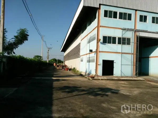 โรงงาน ขายในLat Lum Kaeo, Pathum Thani - ทางบริการข้างอาคารสำหรับรถบรรทุก พร้อมแนวต้นไม้และสายไฟ