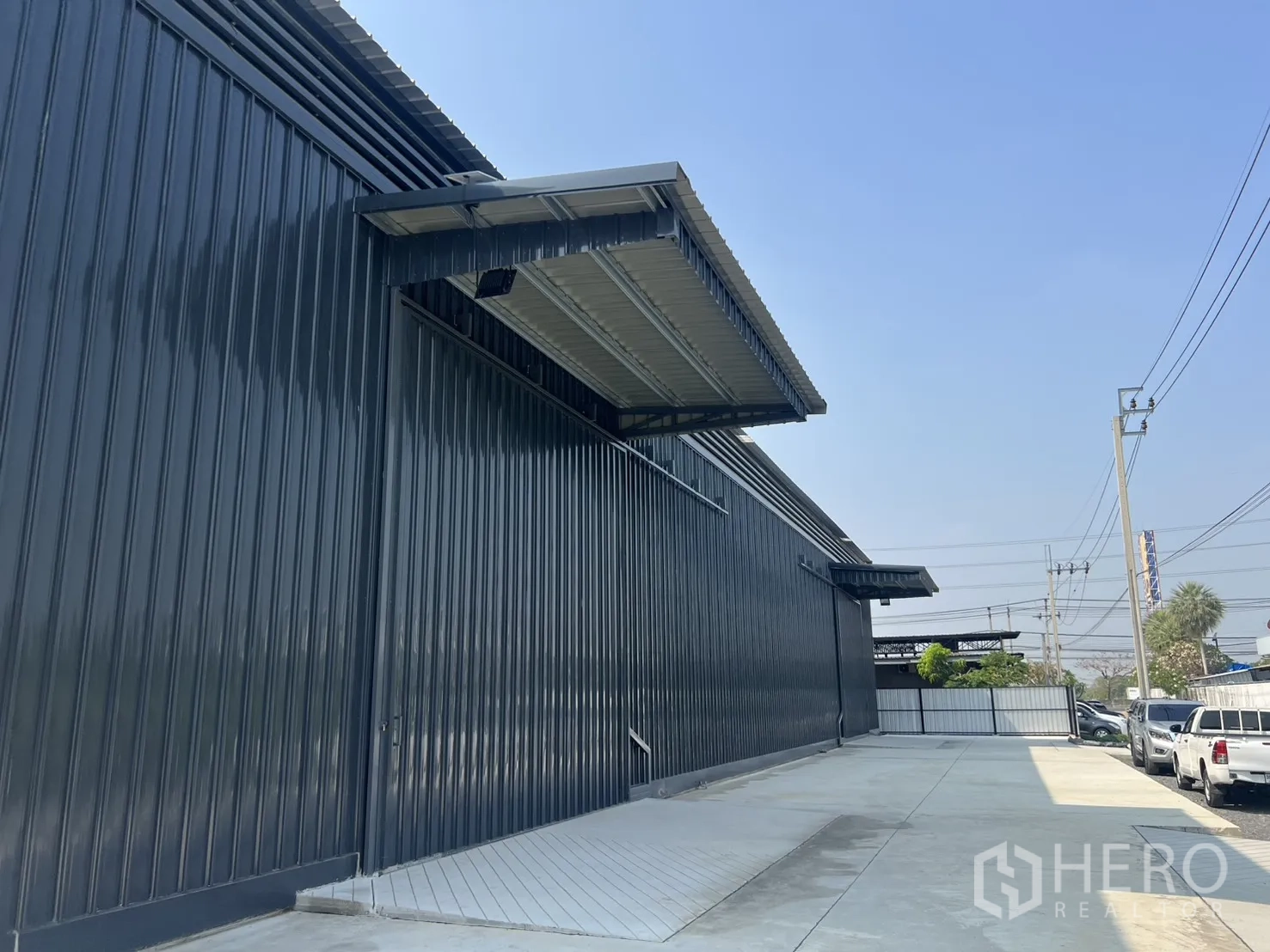 货栈 出租在Lat Krabang, Bangkok - 现代金属外墙仓库外观，带遮雨装卸平台与宽阔混凝土车道。