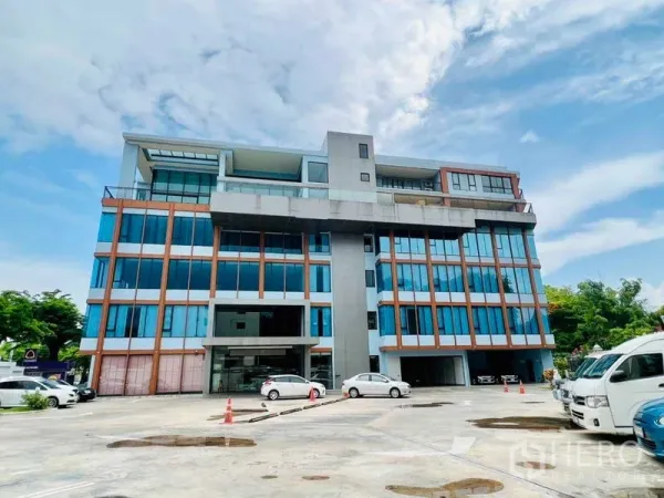 Office Space for rent in Khlong San, Bangkok - Mid‑rise office building with glass facade and on‑site parking area in front.