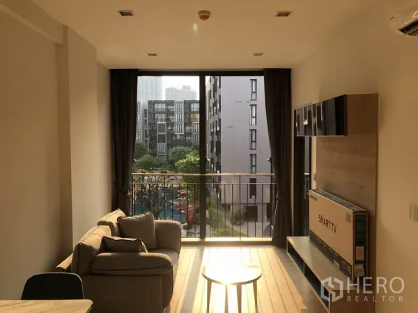 คอนโด ให้เช่าในWatthana, Bangkok - พื้นที่นั่งเล่นมีหน้าต่างจรดเพดานและระเบียง มองเห็นสวนและสระว่ายน้ำ