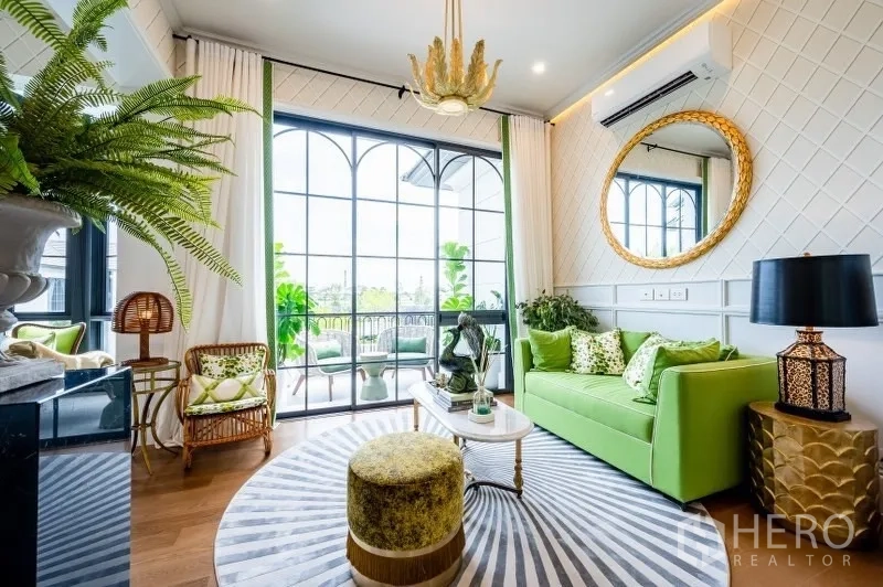 บ้าน ขายในBang Kapi, Bangkok - ห้องนั่งเล่นสว่าง โซฟาสีเขียว และประตูหน้าต่างโค้งสูงเปิดสู่ระเบียง