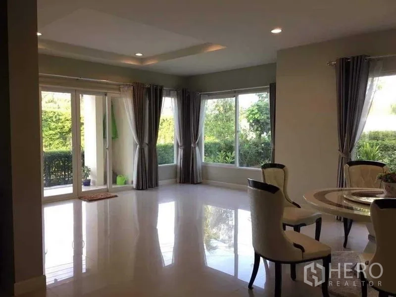 独立式住宅 出售在Bang Kruai, Nonthaburi - 开放式客厅，亮面地砖，推拉落地门与花园景观。
