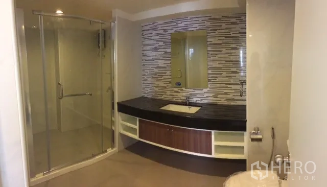 Condominium for rent or sale in Chatuchak, Bangkok - Modern bathroom with glass-enclosed shower, long vanity, and mosaic tile backsplash.