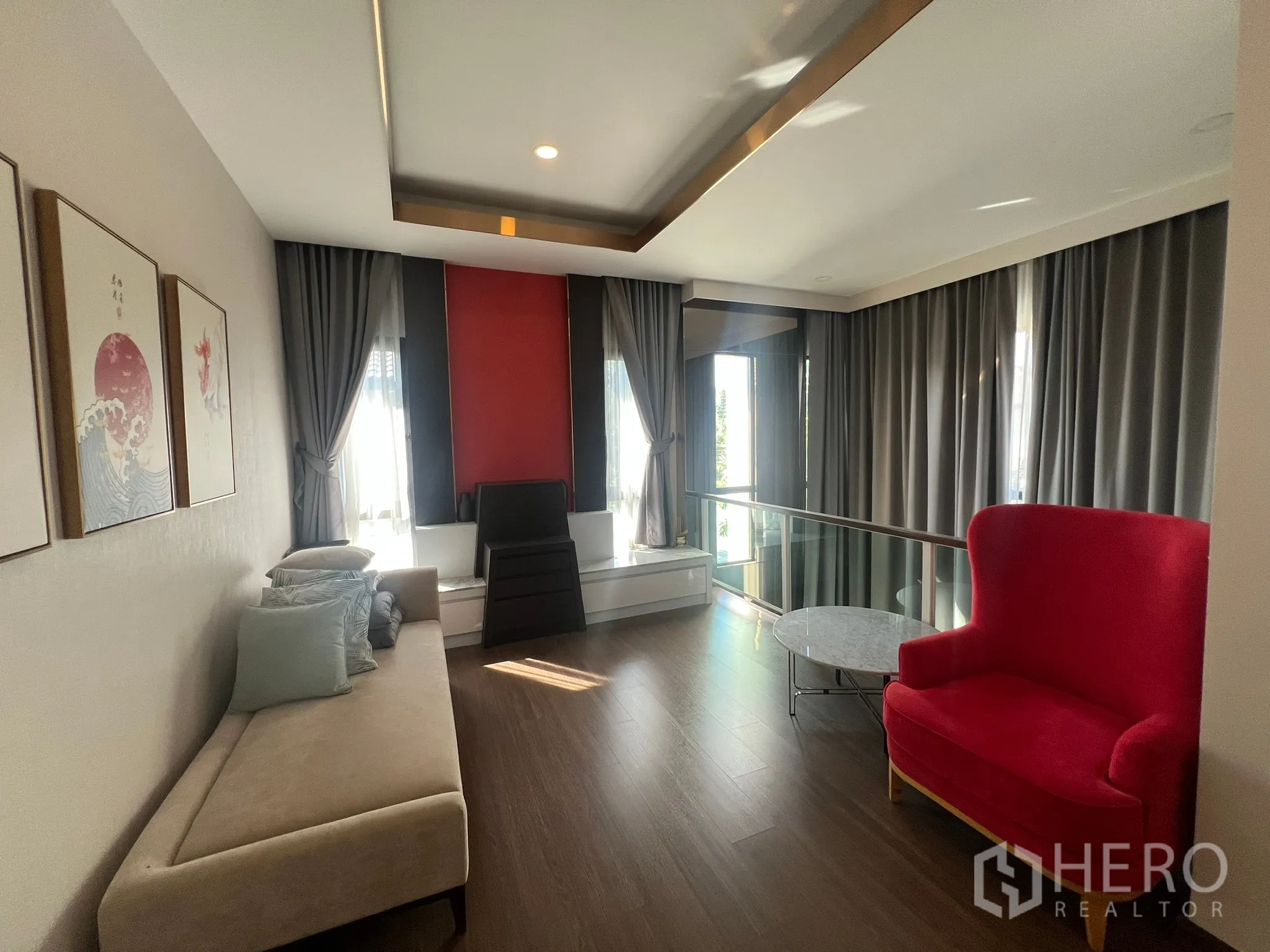 บ้าน ให้เช่าหรือขายในPrawet, Bangkok - โถงพักผ่อนชั้นบน โซฟา ผนังสีแดง และราวกระจก