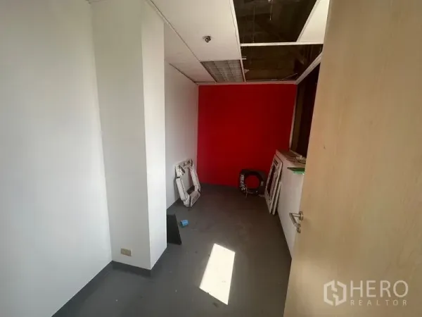 Office Space for rent in Khlong Toei, Bangkok - Compact room with red accent wall and daylight, ideal as a meeting room or manager’s office.