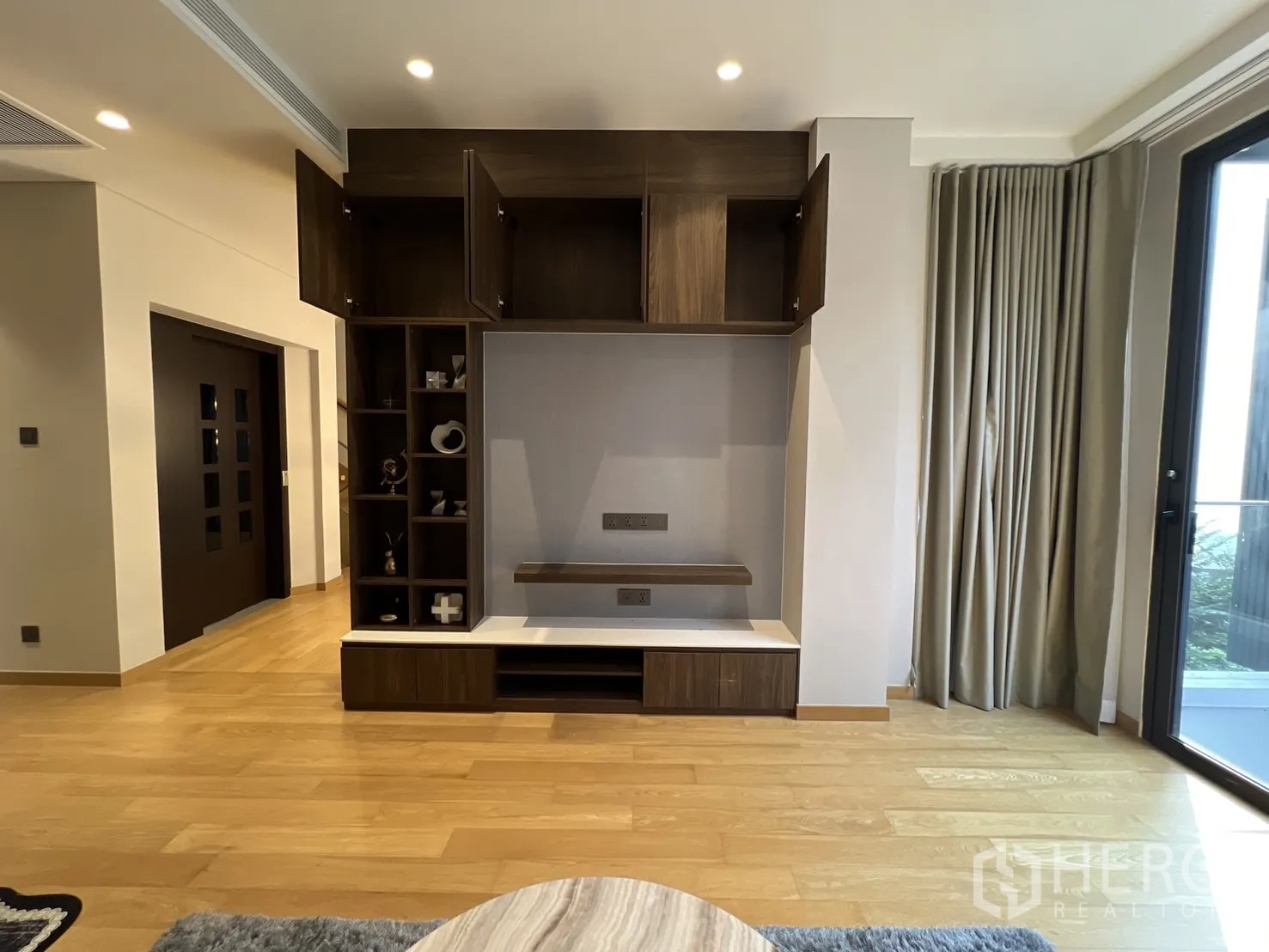 独立式住宅 出租在Suan Luang, Bangkok - 媒体墙柜体与开放搁架，通向阳台