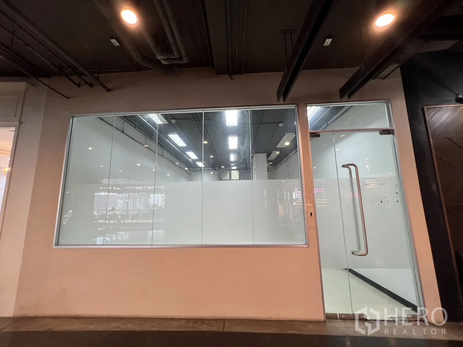 零售空间 出租 - 室内商场内的整面落地玻璃门面与玻璃门店铺。