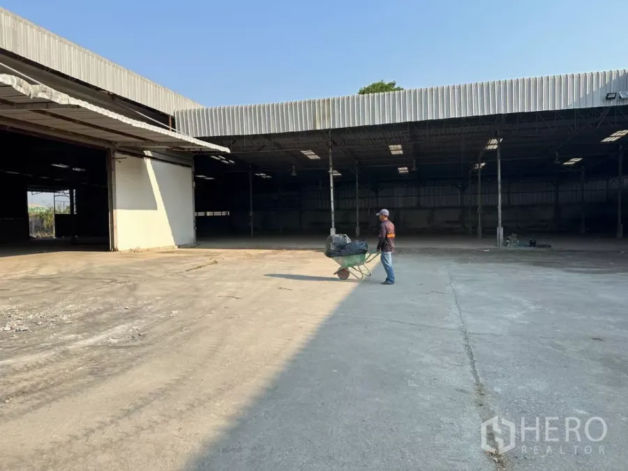 工厂 出租在Samut Prakan - 宽阔混凝土场地与大型遮棚装卸区的工厂院内景