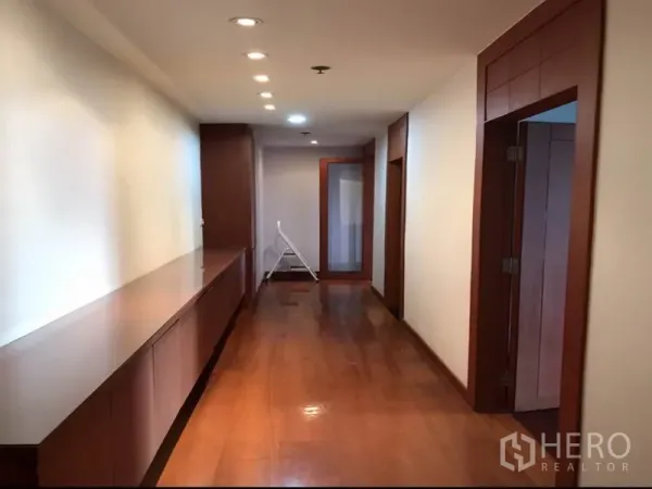 Condominium for rent or sale in Watthana, Bangkok - Long corridor with built-in cabinets and recessed ceiling lights.