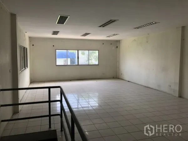 Factory for rent in Khlong Luang, Pathum Thani - Open-plan second-floor office with tiled flooring and windows providing natural light.