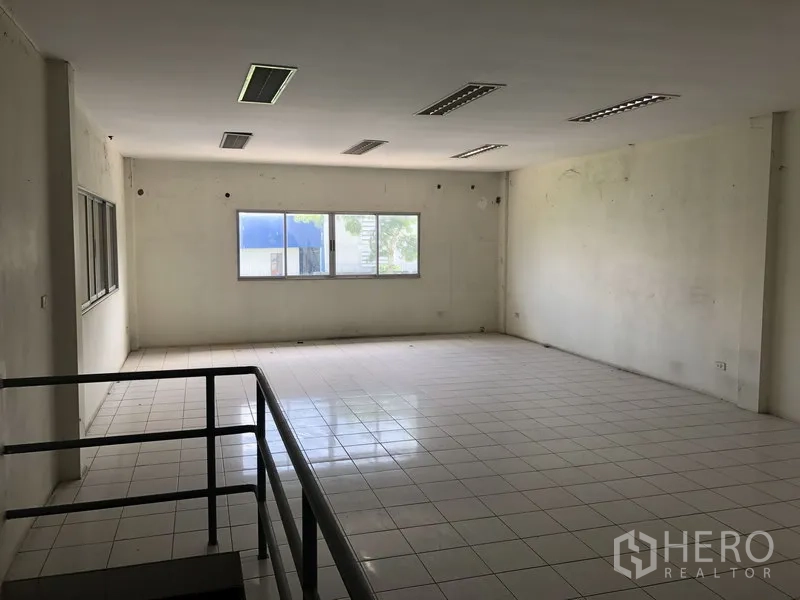 Factory for rent in Khlong Luang, Pathum Thani - Open-plan second-floor office with tiled flooring and windows providing natural light.