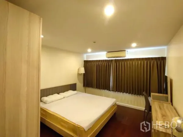 Condominium for rent or sale in Bang Rak, Bangkok - Air‑conditioned bedroom with king bed, wood furniture, and blackout curtains.
