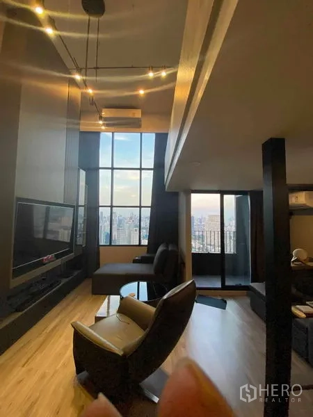 公寓 出租或出售在Sathon, Bangkok - 高挑客厅，巨幕电视、吊灯与阳台连接。