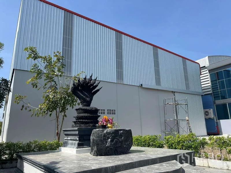 货栈 出租在Prawet, Bangkok - 临街视角的金属覆层仓库立面，前方景观平台与绿化。