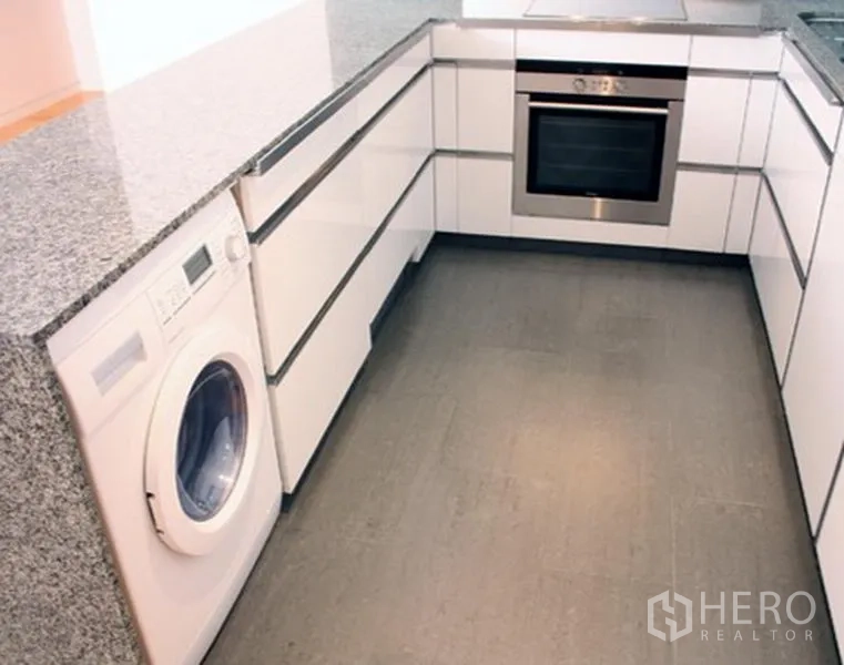 Condominium for sale in Sathon, Bangkok - U-shaped modern kitchen with granite counters, built-in oven and washing machine in Sathon.