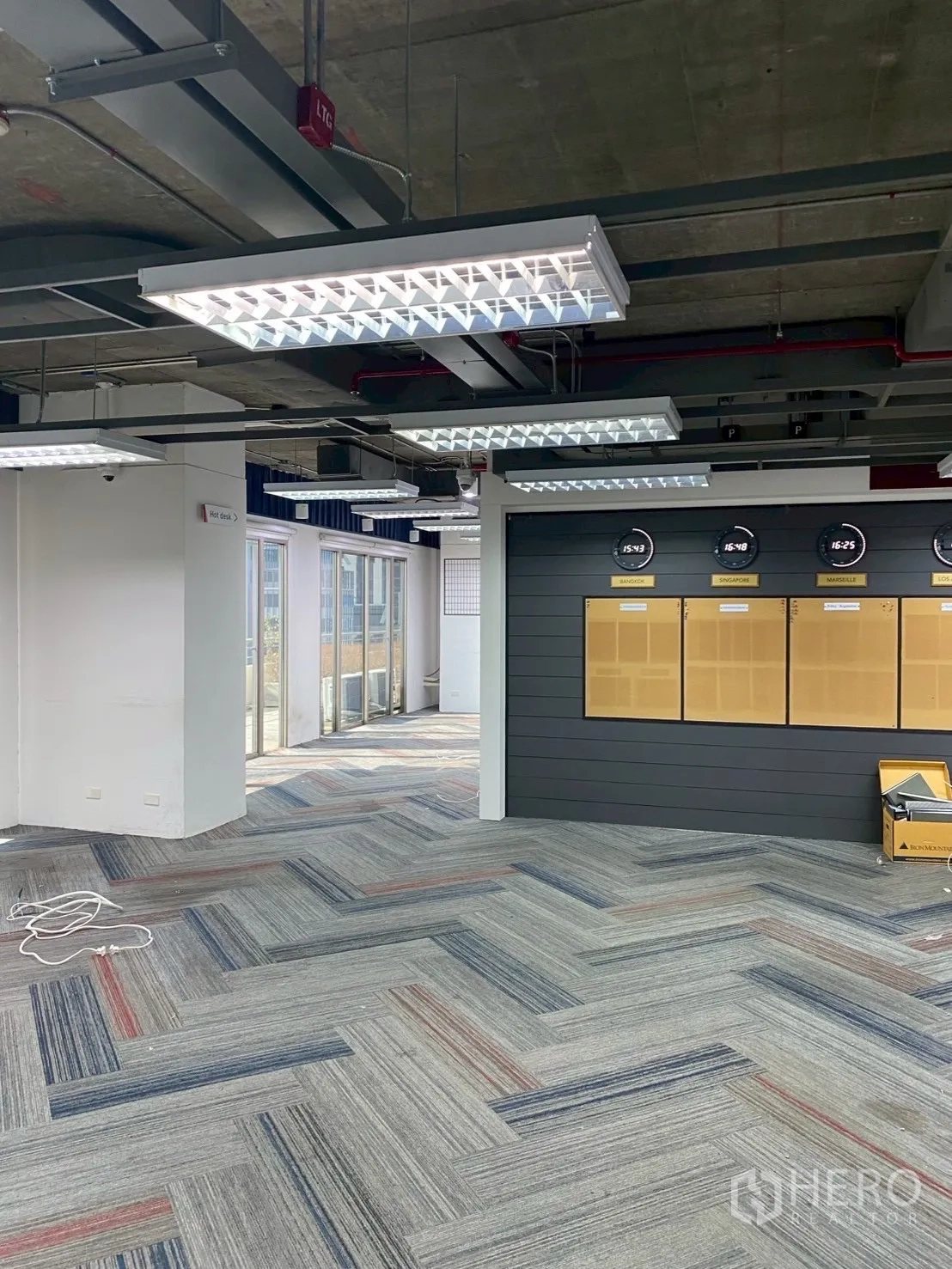 办公室 for rent in Watthana, Bangkok - 开放办公区设特色墙与时钟，旁连露台门。