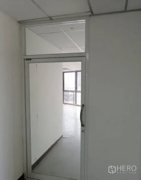 办公空间 出租在Pathum Wan, Bangkok - 玻璃门入口通向明亮办公室，可见转角大窗与城市景观。