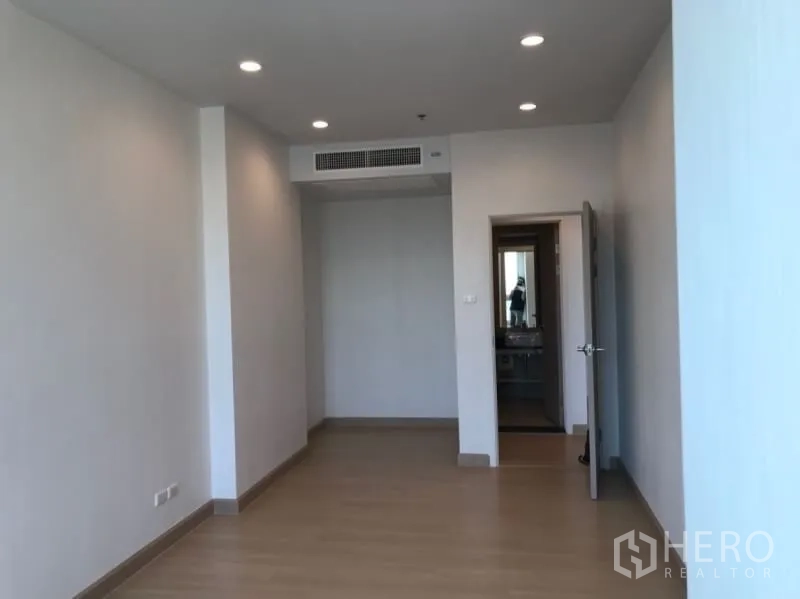 Condominium for sale in Yan Nawa, Bangkok - Hallway with downlights and built-in air-conditioning vent leading toward a modern bathroom.