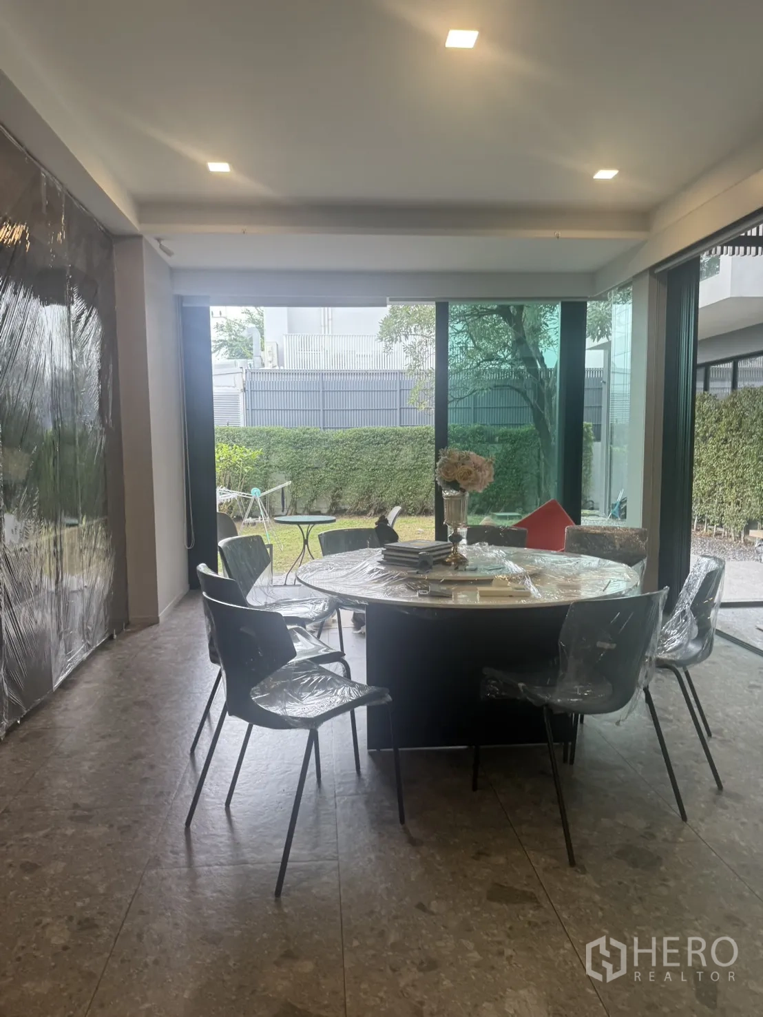 Detached House for rent in Saphan Sung, Bangkok - Ground-floor dining room with a round table opening to a private landscaped garden via sliding doors.