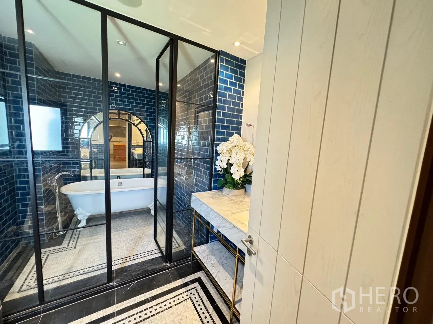 Detached House for rent or sale in Prawet, Bangkok - Bathroom featuring clawfoot bathtub behind glass and blue tiles.