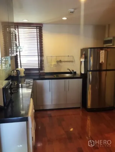 คอนโด ให้เช่าในPathum Wan, Bangkok - ครัวสมัยใหม่ เคาน์เตอร์หินสีดำ ตู้เย็นสเตนเลส และเตาไฟฟ้า