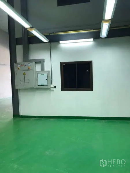 โรงงาน ให้เช่าในBang Phli, Samut Prakan - พื้นที่ผลิตพื้นอีพ็อกซี่สีเขียว หน้าต่าง และตู้ควบคุมไฟฟ้าภายใต้ไฟนีออน