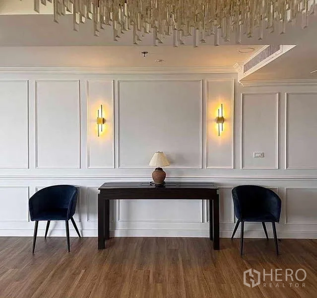 คอนโด ให้เช่าหรือขายในKhlong Toei, Bangkok - มุมนั่งพักผ่อน เก้าอี้กำมะหยี่สีน้ำเงินสองตัว โต๊ะคอนโซล และไฟตกแต่ง