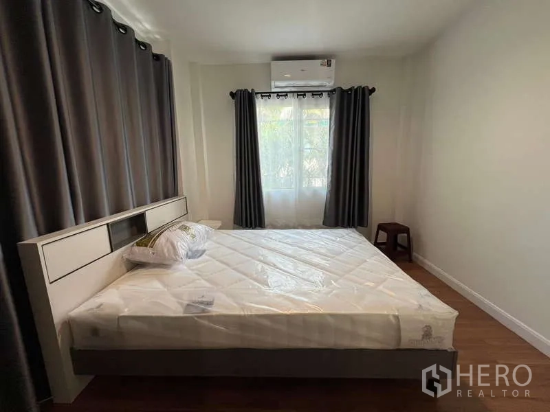บ้าน ให้เช่าในBang Kapi, Bangkok - ห้องนอนอบอุ่นเตียงคู่ ม่านทึบสีเข้ม และเครื่องปรับอากาศติดผนัง