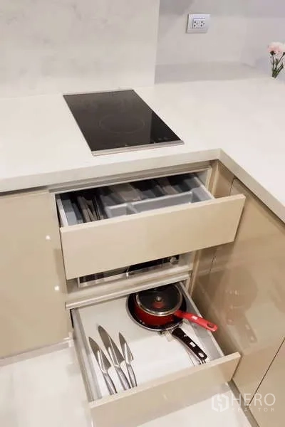 คอนโด ให้เช่า - ลิ้นชักครัวเปิดโชว์อุปกรณ์เครื่องครัวข้างเตาไฟฟ้า